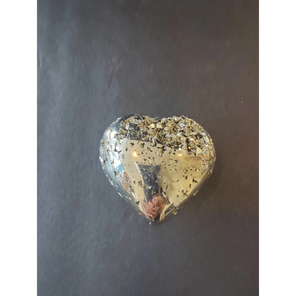 A heart-shaped polished pyrite pendant with a reflective metallic surface embedded with golden flecks