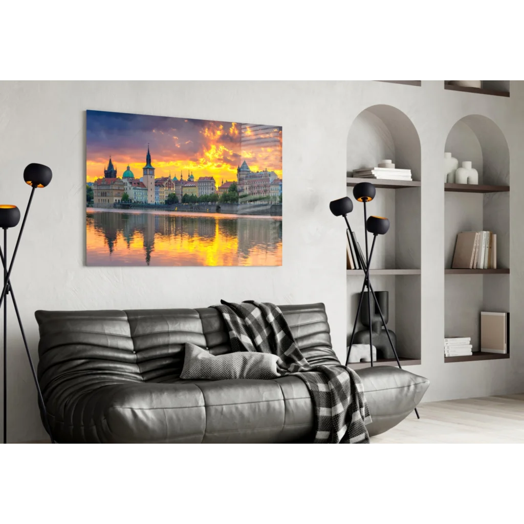 Golden sunset cityscape glass wall art canvas print over black sofa