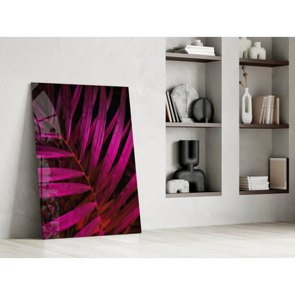Vibrant magenta palm leaf glass wall art leaning on white wall
