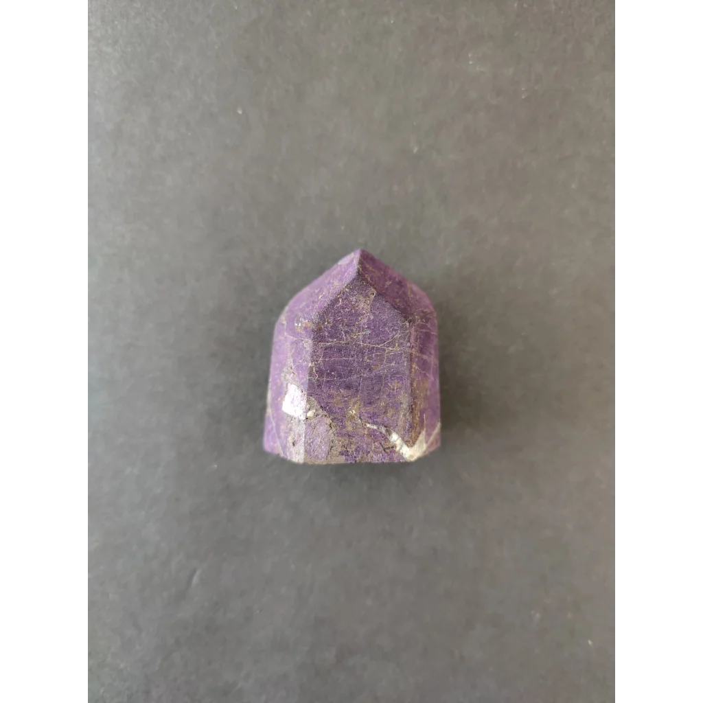 Faceted purple amethyst crystal with golden inclusions in Purpurite Lapidary