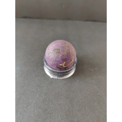 Purpurite Lapidary: smooth round purple stone with golden streaks in display stand