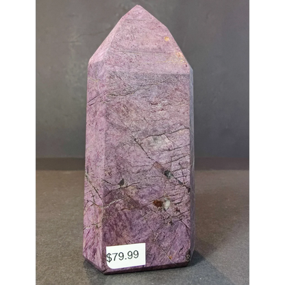 A polished purple purpurite polished obelisk with natural striations and pointed top decorative obelisk tower sculpture
