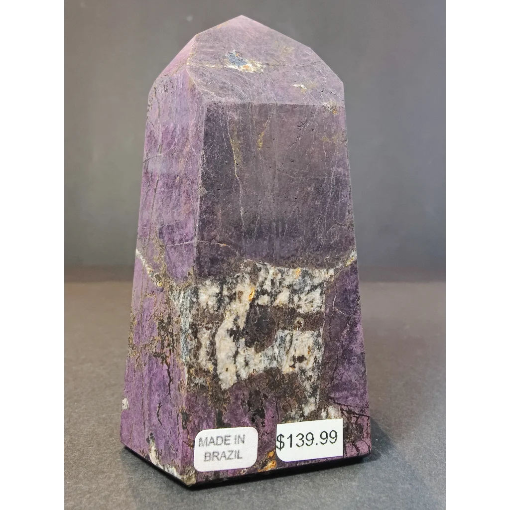 Polished purple amethyst purpurite polished obelisk tower sculpture with faceted pyramid top and natural mineral inclusions