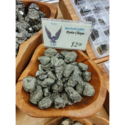 Shiny greenish-gray pyrite chispa rocks in wooden bowl