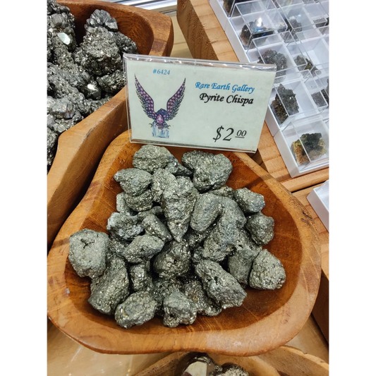 Shiny greenish-gray pyrite chispa rocks in wooden bowl
