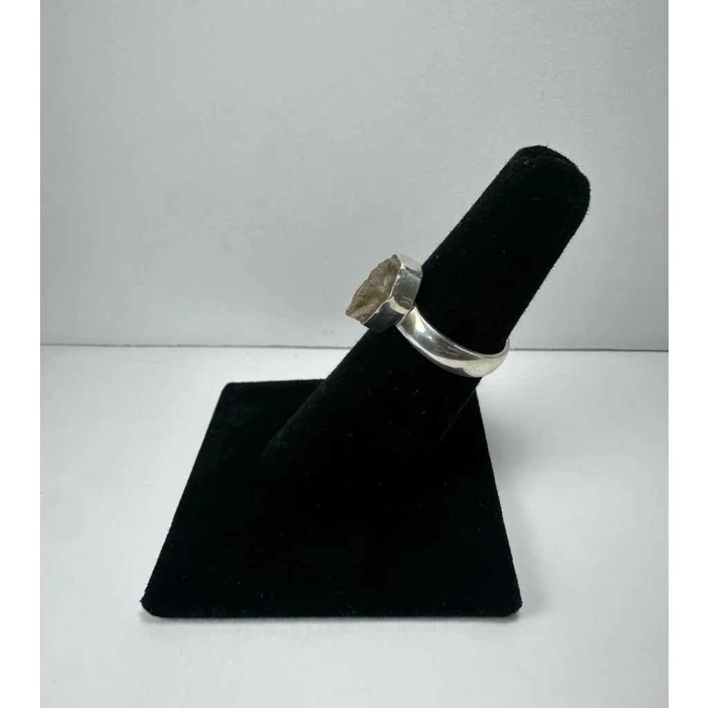 Silver quartz ring with raw translucent greenish stone in polished band