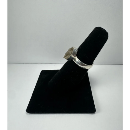 Silver quartz ring with raw translucent greenish stone in polished band