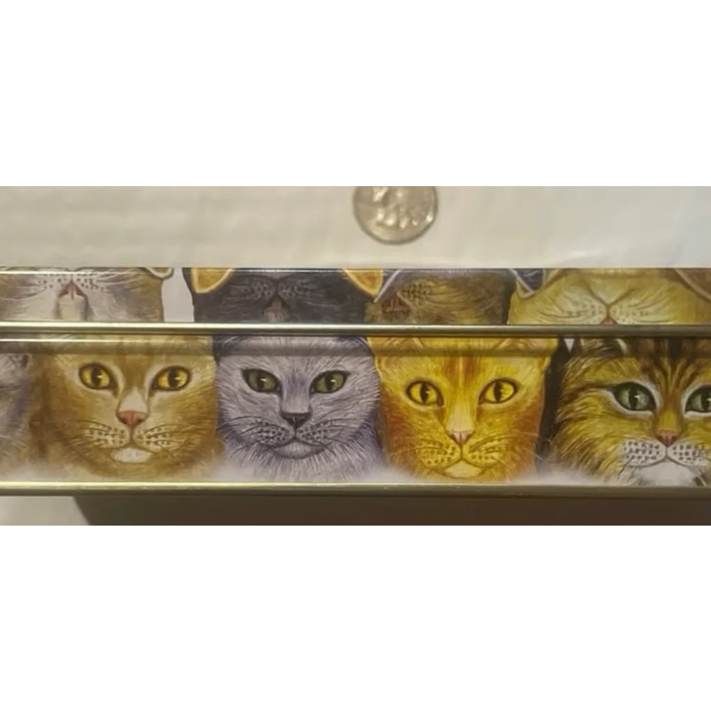 Four adorable cat faces peek out from a quirky vintage tin by Persis Clayton Wiers