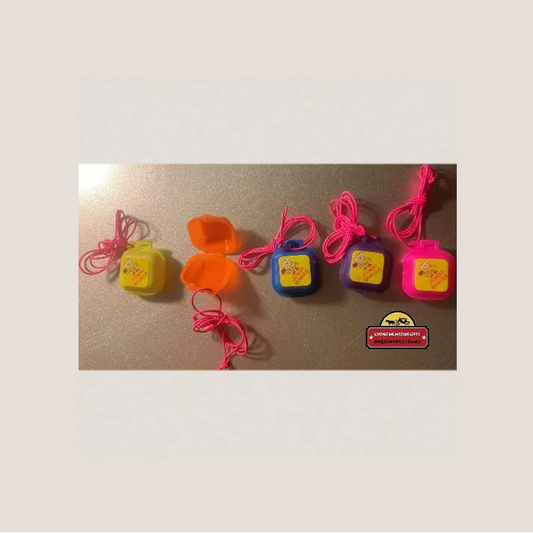 Colorful plastic candy dispensers with pink cords for Rad 80s Jumbo Burger charms vintage vibes