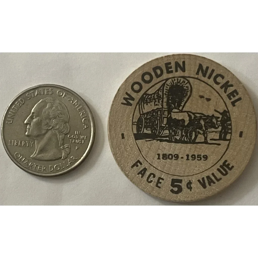 Vintage wooden nickel from the 1950s featuring a covered wagon and 5¢ VALUE text