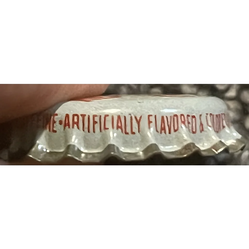 Metal bottle cap with red text reading ARTIFICIALLY FLAVORED from Rare 1960s Red Eye Root Beer