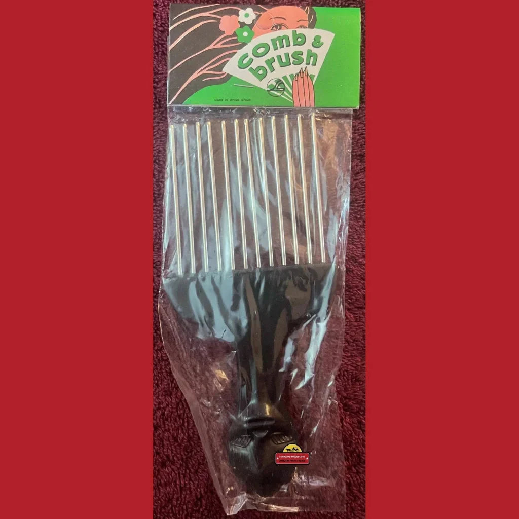 Plastic-wrapped 1960s vintage comb brush combo with a black handle in green packaging