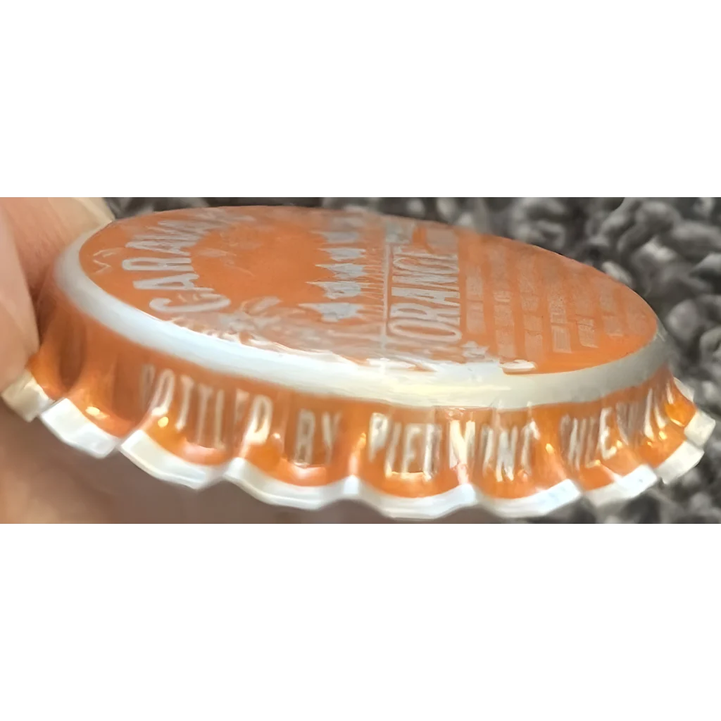 Orange bottle cap with ridged edges from Rare 1970s Salisbury NC Caravan Orange Soda