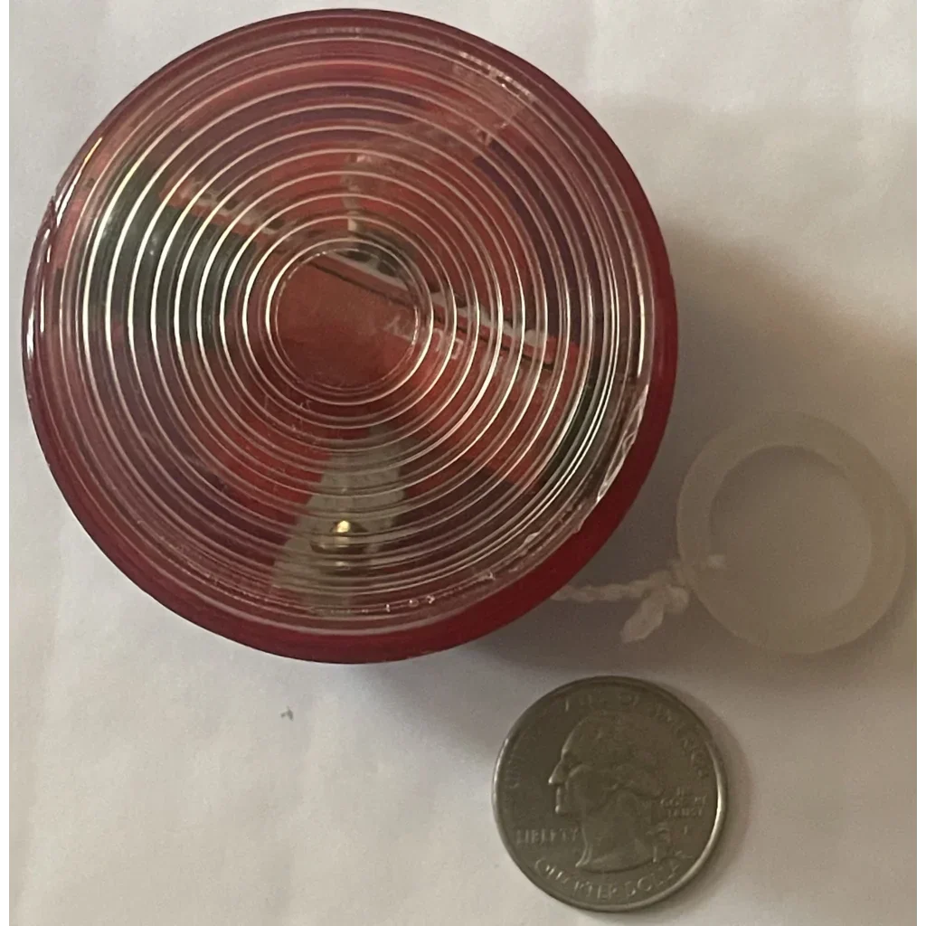 Circular red plastic lid with concentric ridges for a 1980s vintage light yo-yo