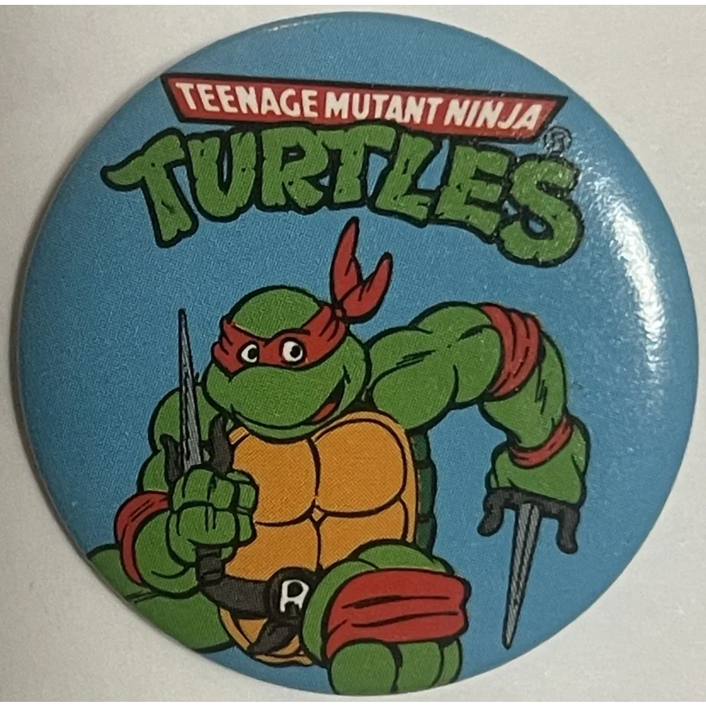 Circular Raphael Pin featuring a Teenage Mutant Ninja Turtle on a blue background