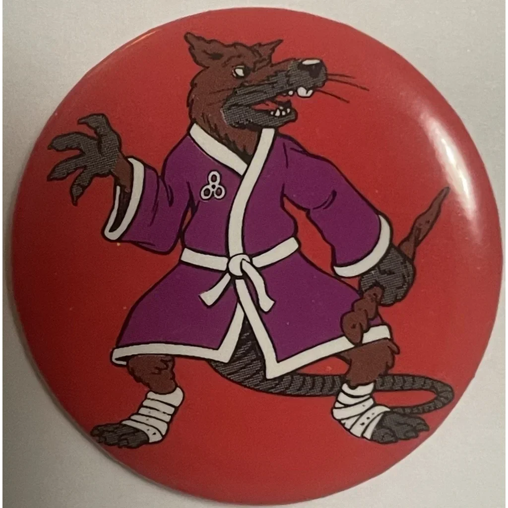 Cartoon rat in purple martial arts uniform on red for Mutant Ninja Turtles pin