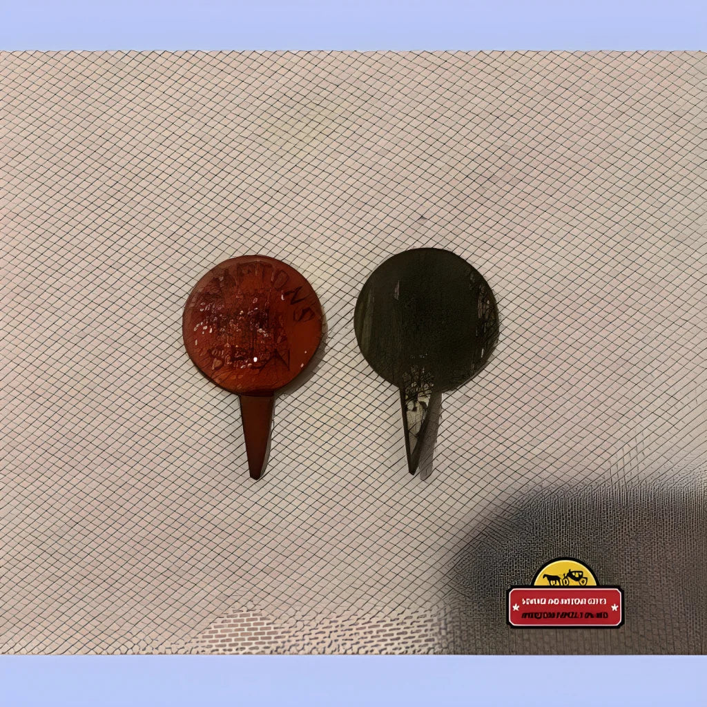 Two golf tees in red and black beside the Rare Antique Hampton Home Spun Tin Tobacco Tag