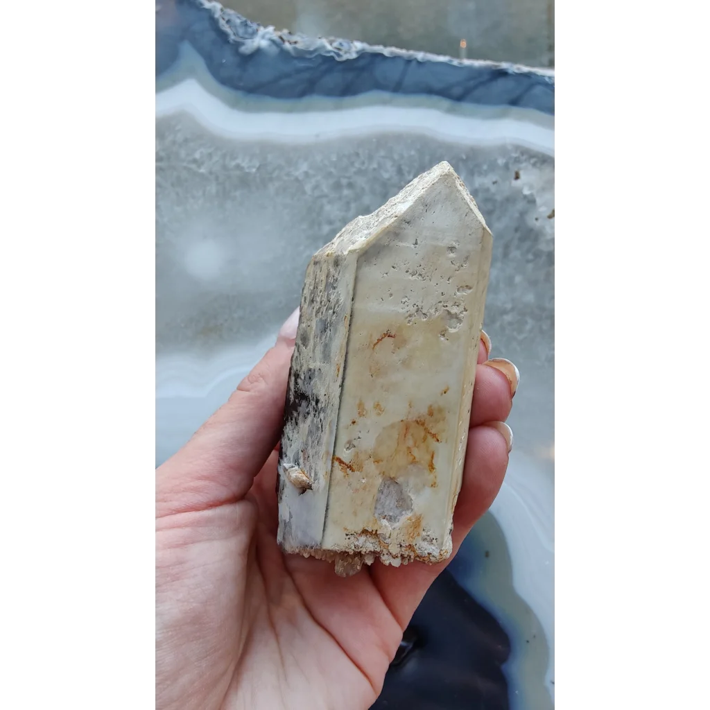 Hand holding rare Brazilian smokey quartz point with lodalite inclusions