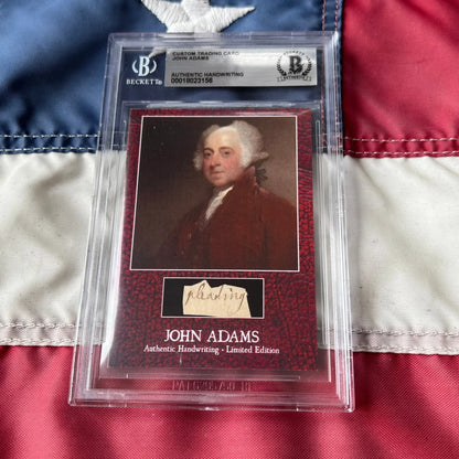 A framed rare john adams custom trading card on deep red textured cardboard featuring adams legal document handwriting cards