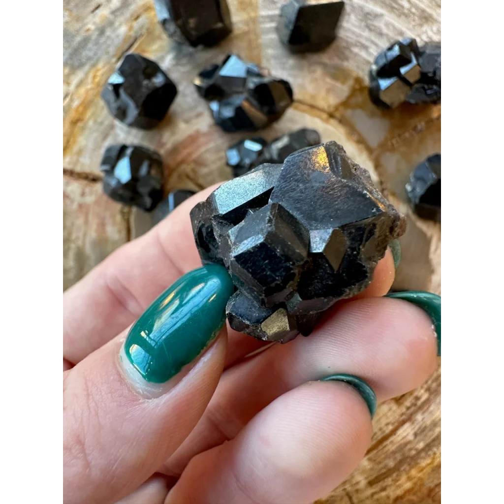 Hand holding rare melanite garnet from Kayes Region, Mali Africa