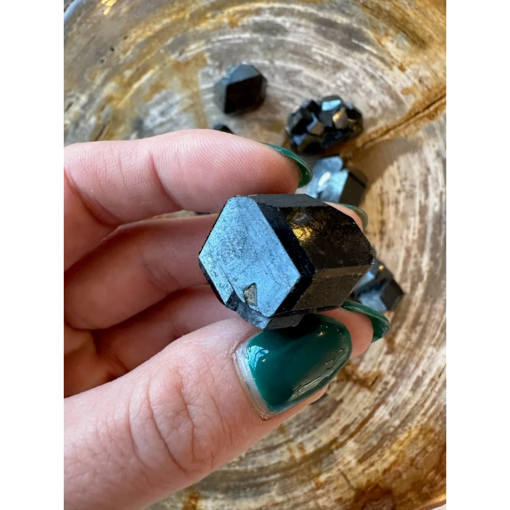 Hand holding rare melanite garnet crystal from Kayes Region, Mali