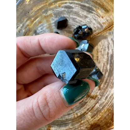 Hand holding rare melanite garnet crystal from Kayes Region, Mali
