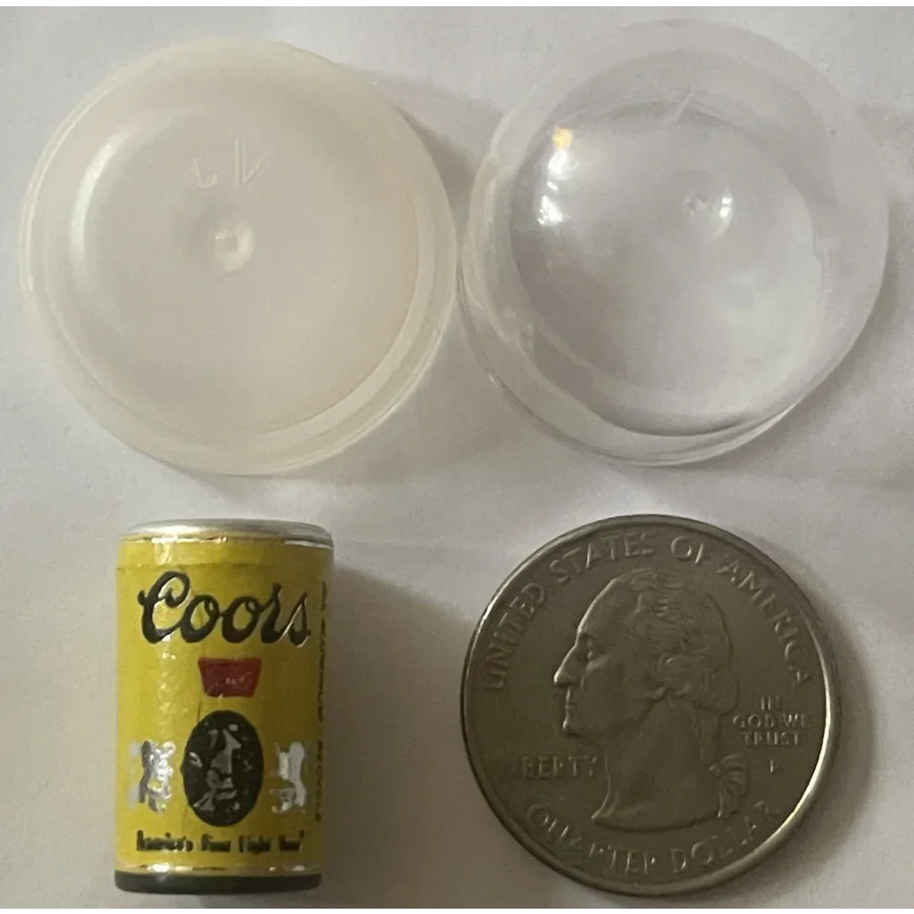 Miniature Coors beer can next to a quarter, showcasing vintage 1970s collectible fun