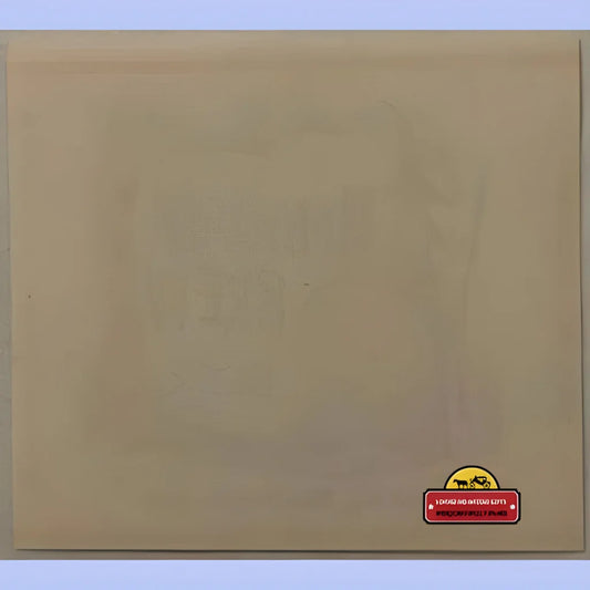 Pale beige vintage beer label backside with faint embossed design and red dealer sticker.