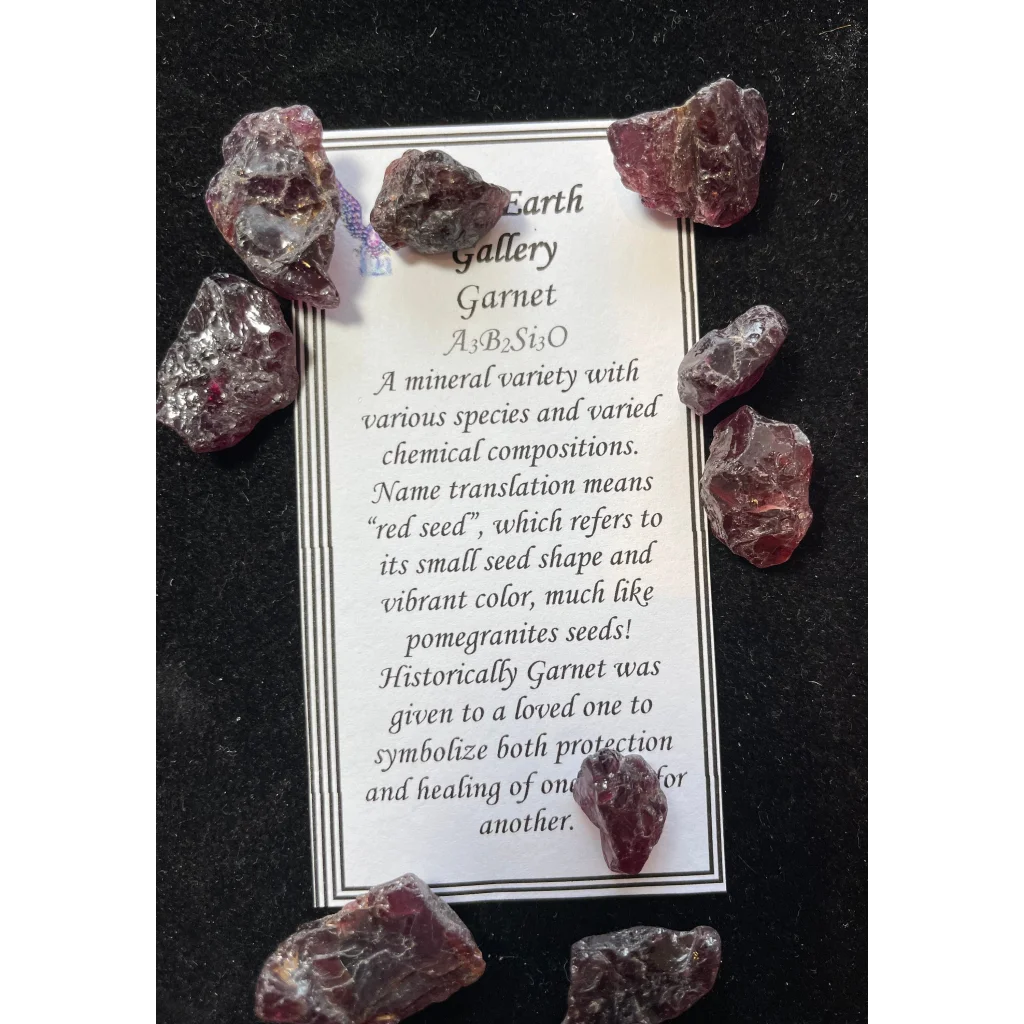 Raw garnet gemstones in deep red and purple hues with info card
