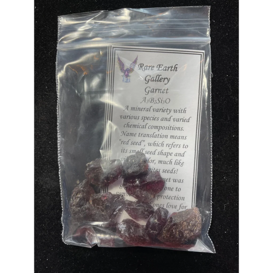 Clear plastic bag of dark red faceted garnets from Rare Earth Gallery