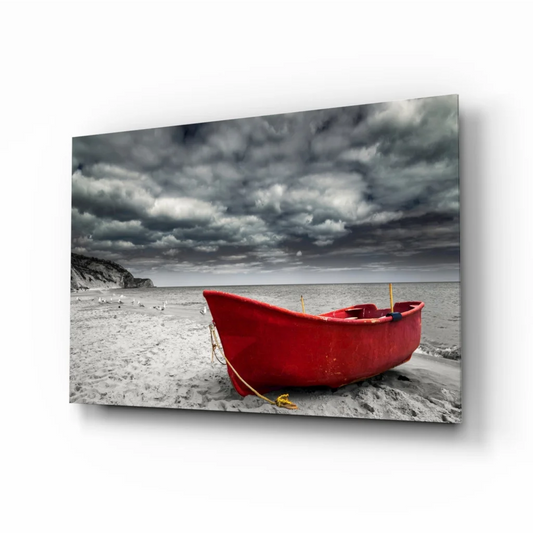 Vibrant red wooden rowboat on sandy beach under stormy sky wall art print