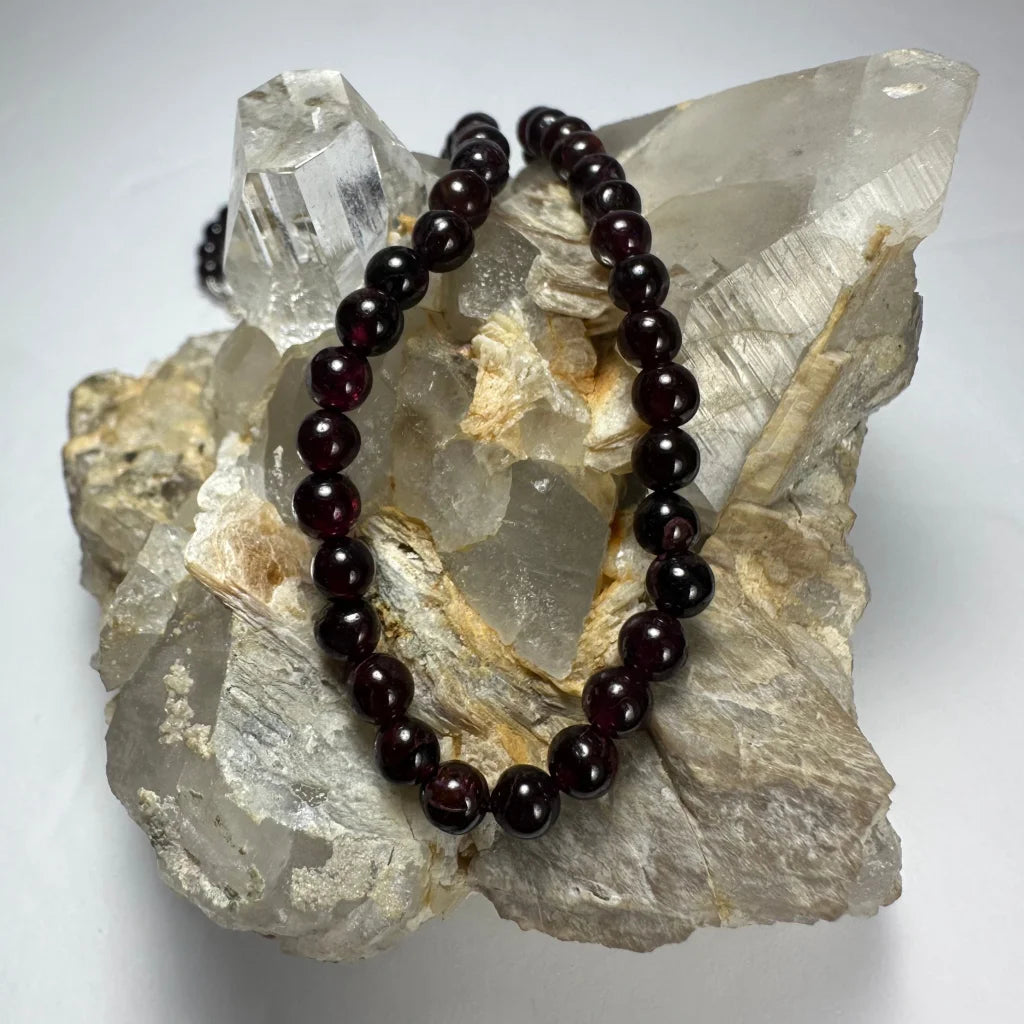 Elegant red garnet round bead necklace on quartz crystals
