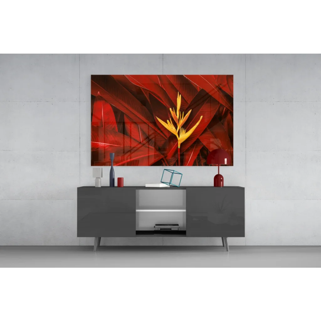 Vibrant red yellow tropical Bird of Paradise glass wall art above gray console