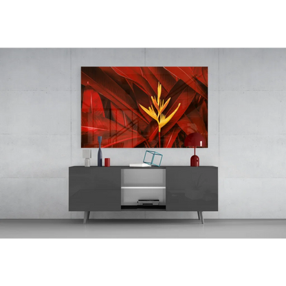 Vibrant red yellow tropical Bird of Paradise glass wall art above gray console