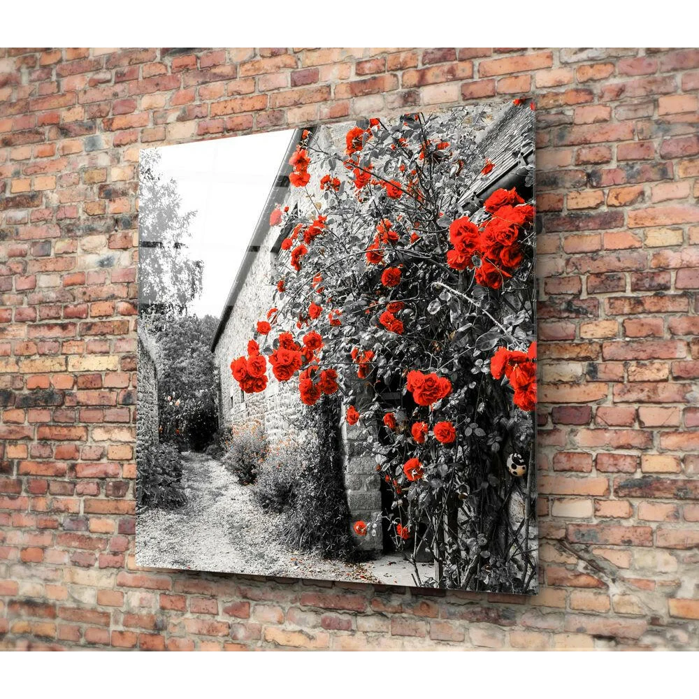 Vibrant red rose vine glass wall art on brick wall with crimson blooms