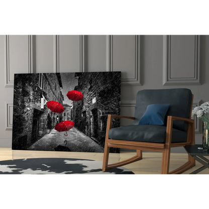 Black-and-white canvas wall art of red umbrellas in cobblestone alley