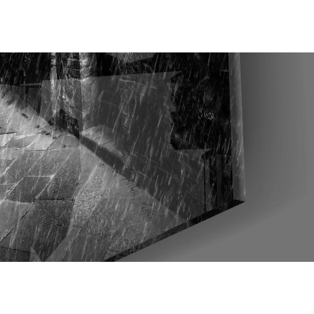 Black-and-white rainy cobblestone alley wall art with red umbrellas