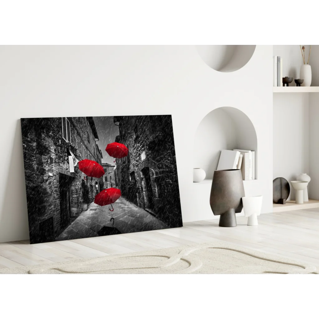 Black-and-white canvas wall art of red umbrellas in cobblestone alley