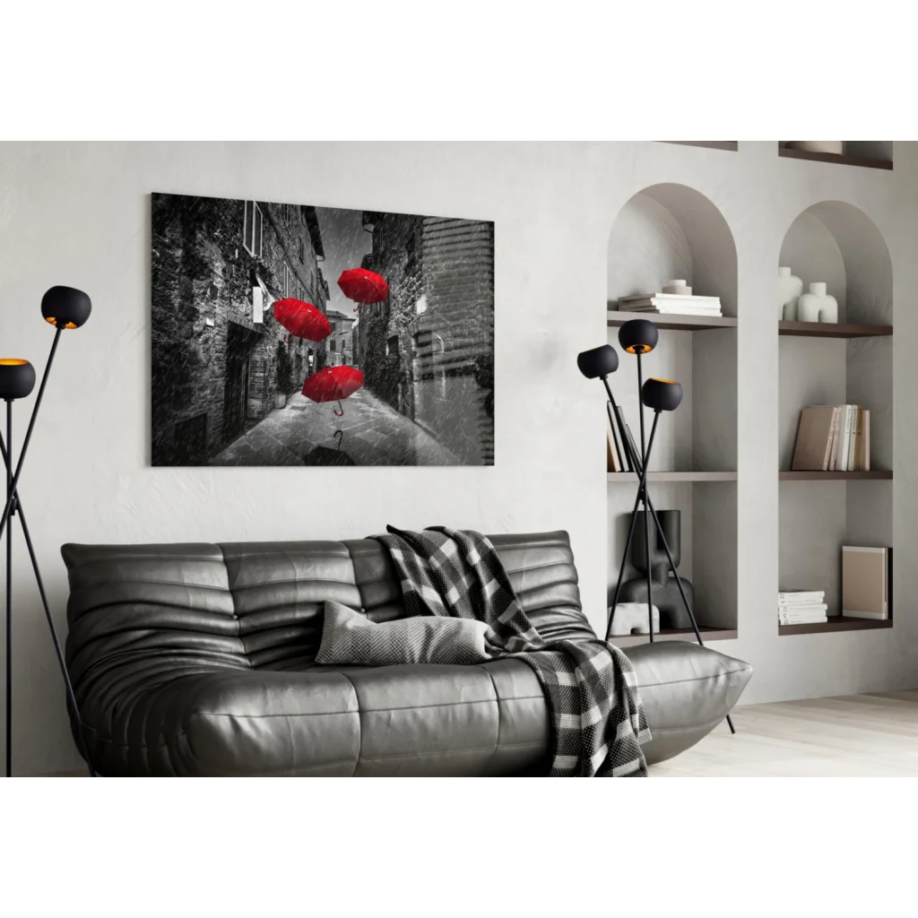 Black and white wall art of red umbrellas in cobblestone alley