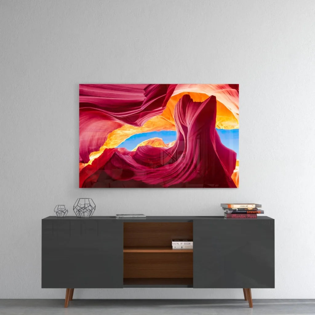 Vibrant red canyon glass wall art with orange hues and blue sky archway