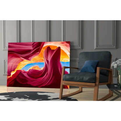 Vibrant glass wall art of swirling red canyon and blue sky archway