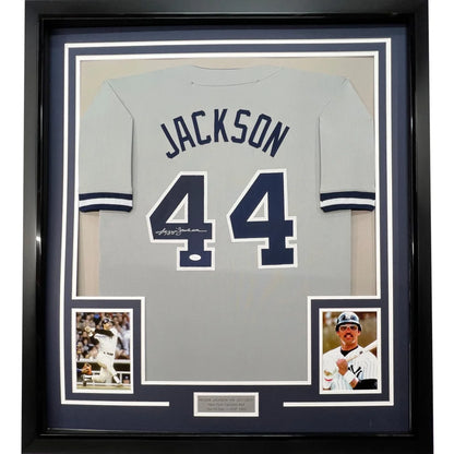 Framed Reggie Jackson autographed jersey with baseball cards and plaque for wall display