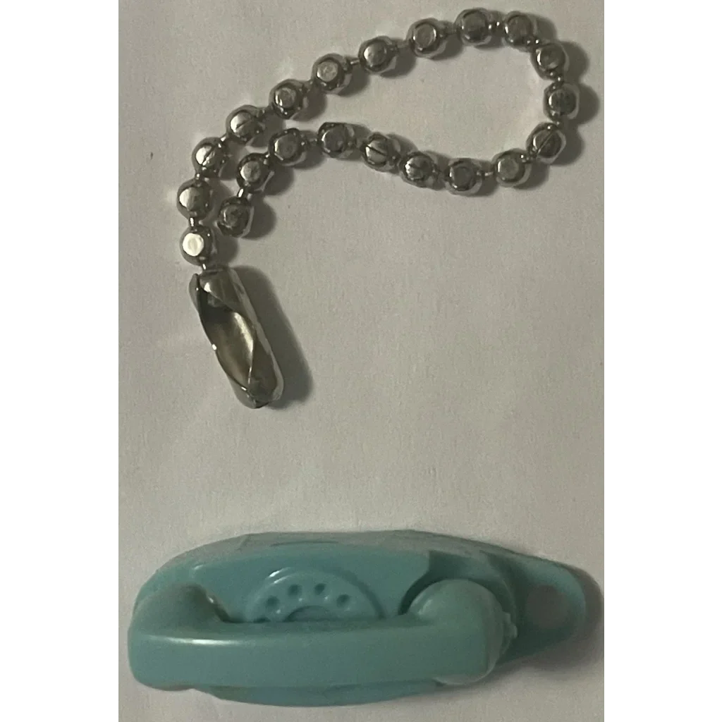 Teal sleeping animal figurine toy on Retro Princess Phones Keychain for vintage charm