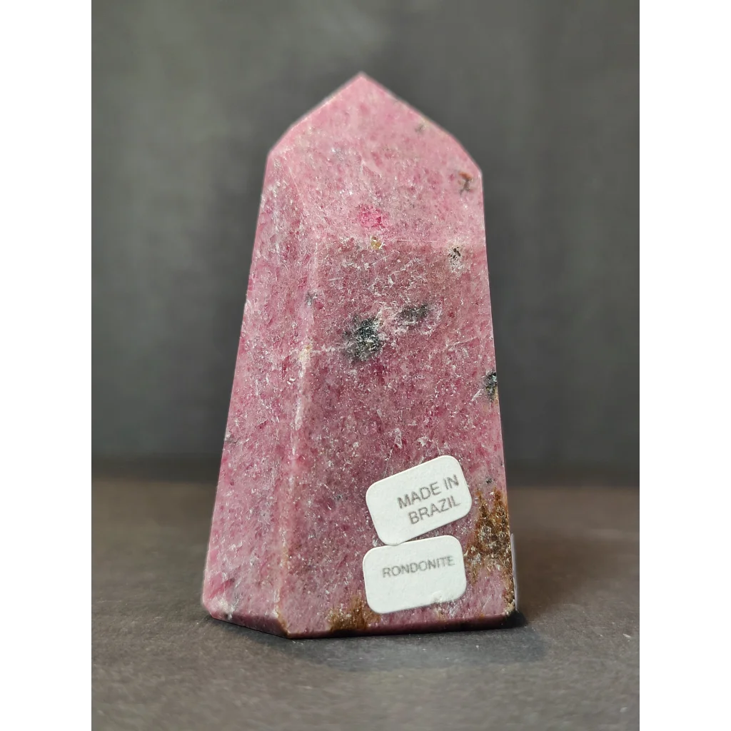 Rhodochrosite polished obelisk tower sculpture featuring a pink faceted crystal point with mineral inclusions and polished surface