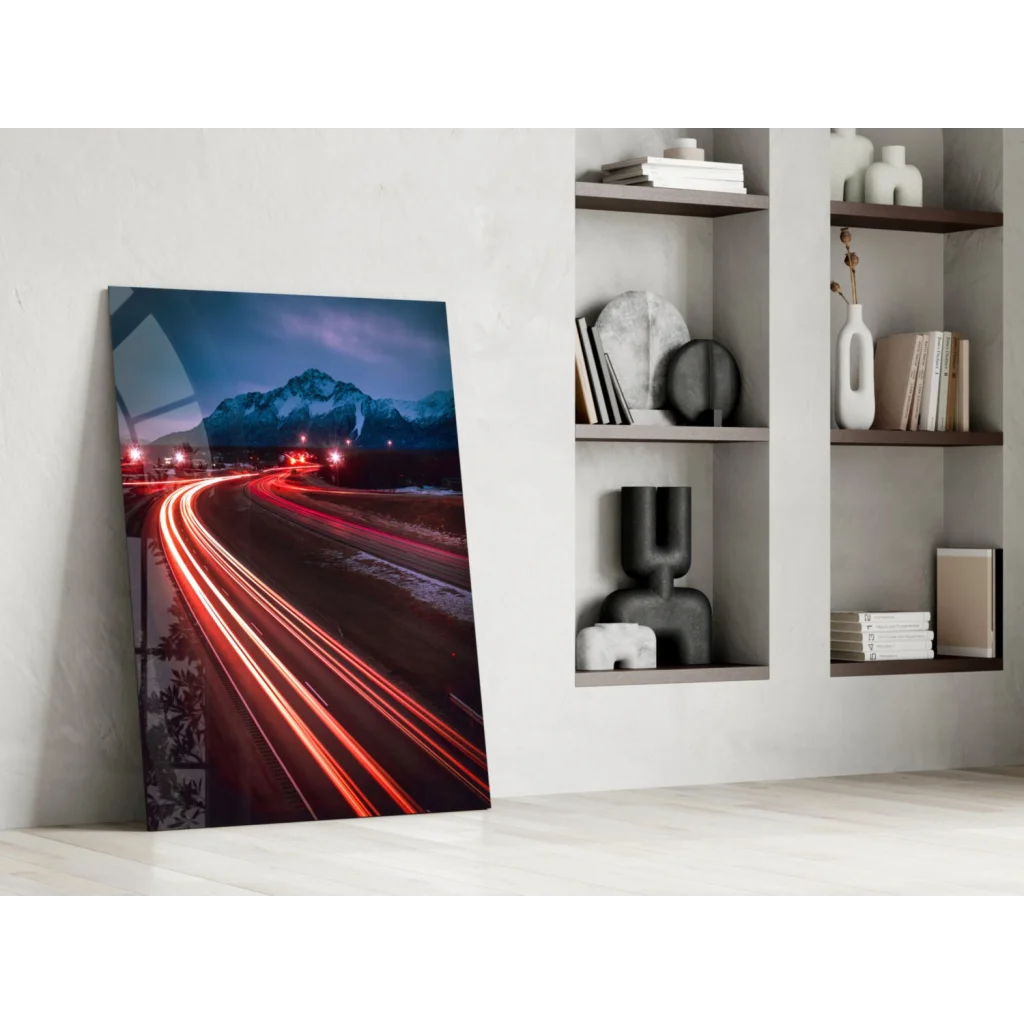 Vibrant glass wall art of nighttime mountain highway with red light trails