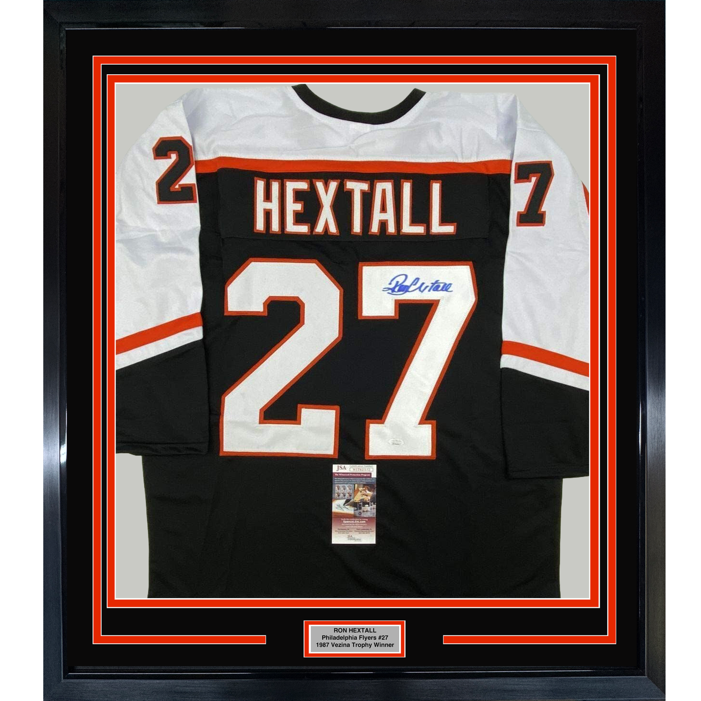 Framed black Philadelphia Flyers hockey jersey #27 signed by Ron Hextall with white and orange trim, displayed flat against white matting.