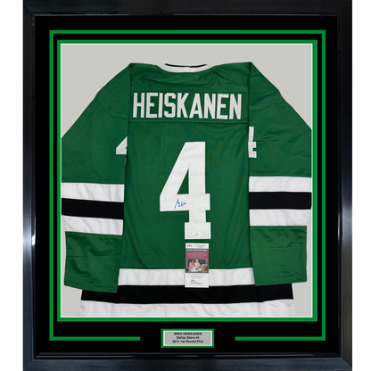 Framed green Dallas Stars hockey jersey number 4 with "HEISKANEN" nameplate, white and black stripes, displayed against white matting with JSA authentication certificate visible.