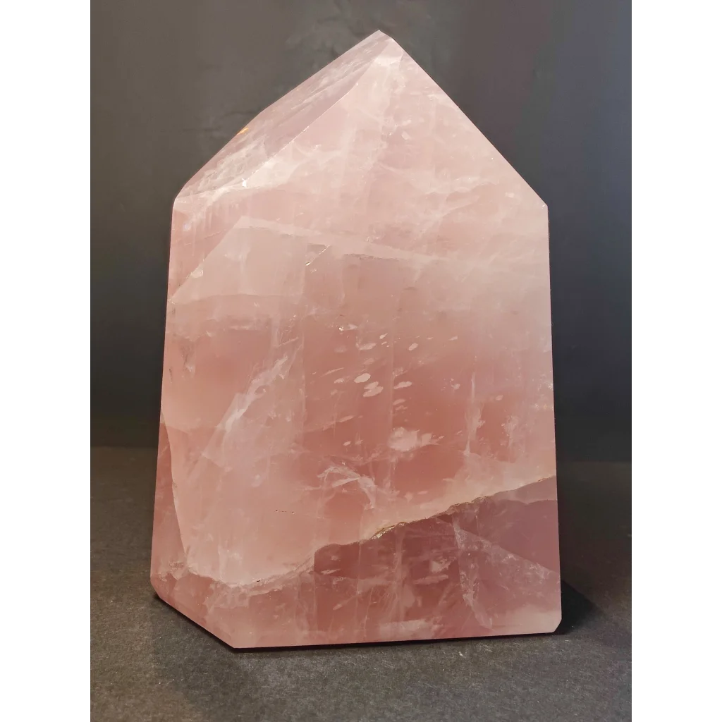 Rose quartz polished obelisk tower sculpture with translucent pink faceted geometric design for decor or healing