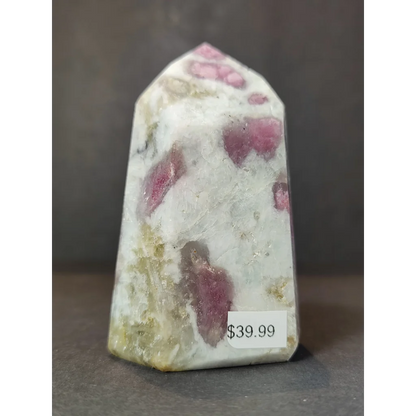 A polished pink and white rhodochrosite quartz polished obelisk tower with natural mineral inclusions obelisk tower sculpture