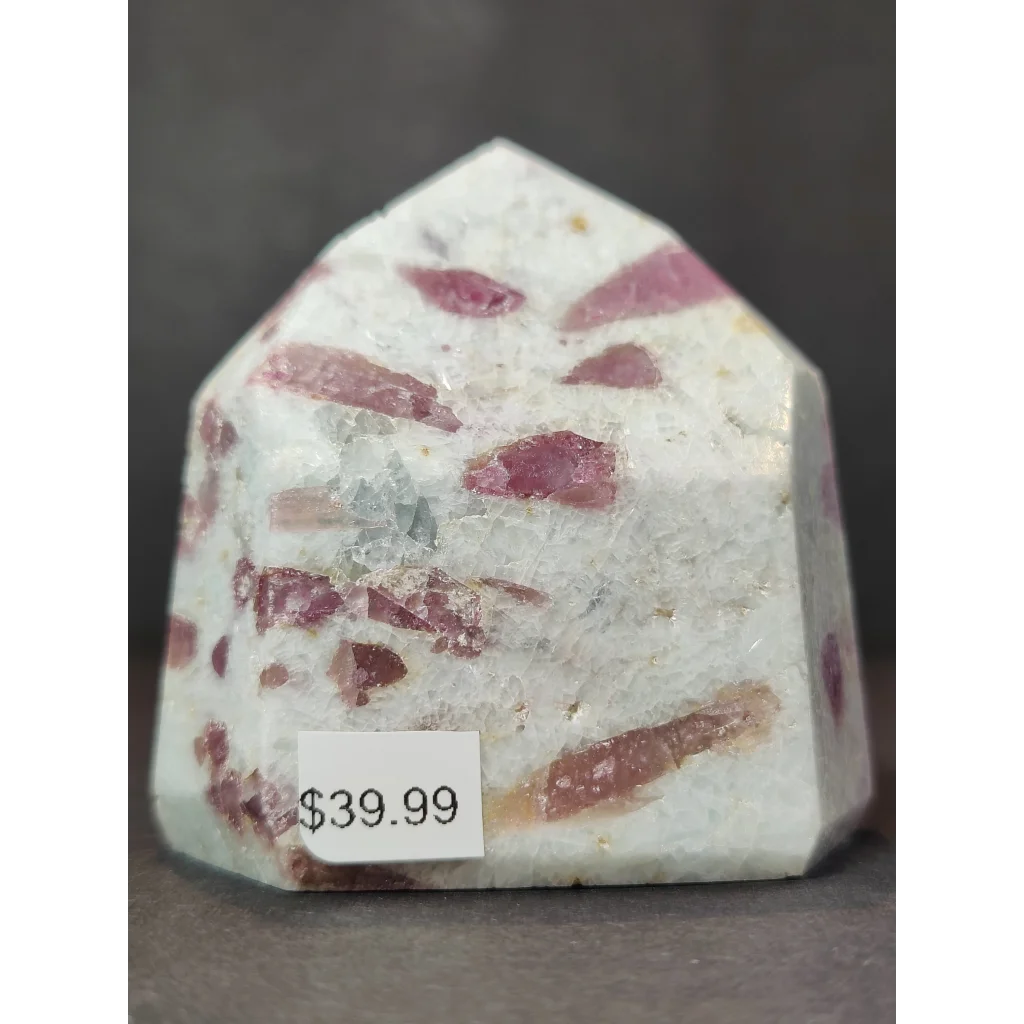 A quartz polished obelisk tower featuring a white base with embedded pinkish-red rubellite crystals